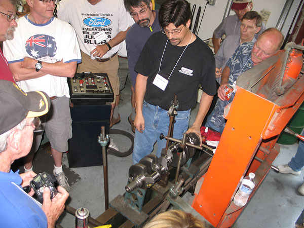 Turning crankshaft to measure wobble.