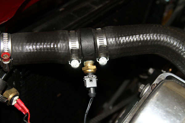 Custom fabricated temperature sensor housing for the electric water pump system.