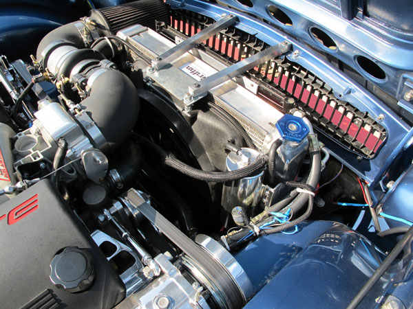 Custom aluminum brackets secure the radiator and AC condenser.